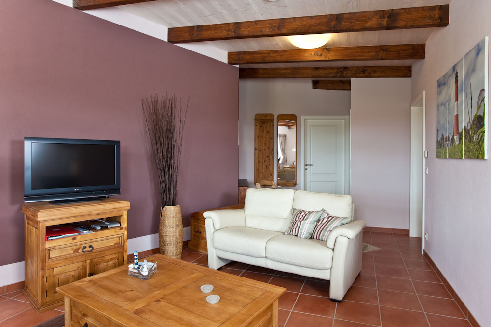 Wohnzimmer mit TV und Durchgang zum Schlafzimmer in der Müllerwohnung Pellworm