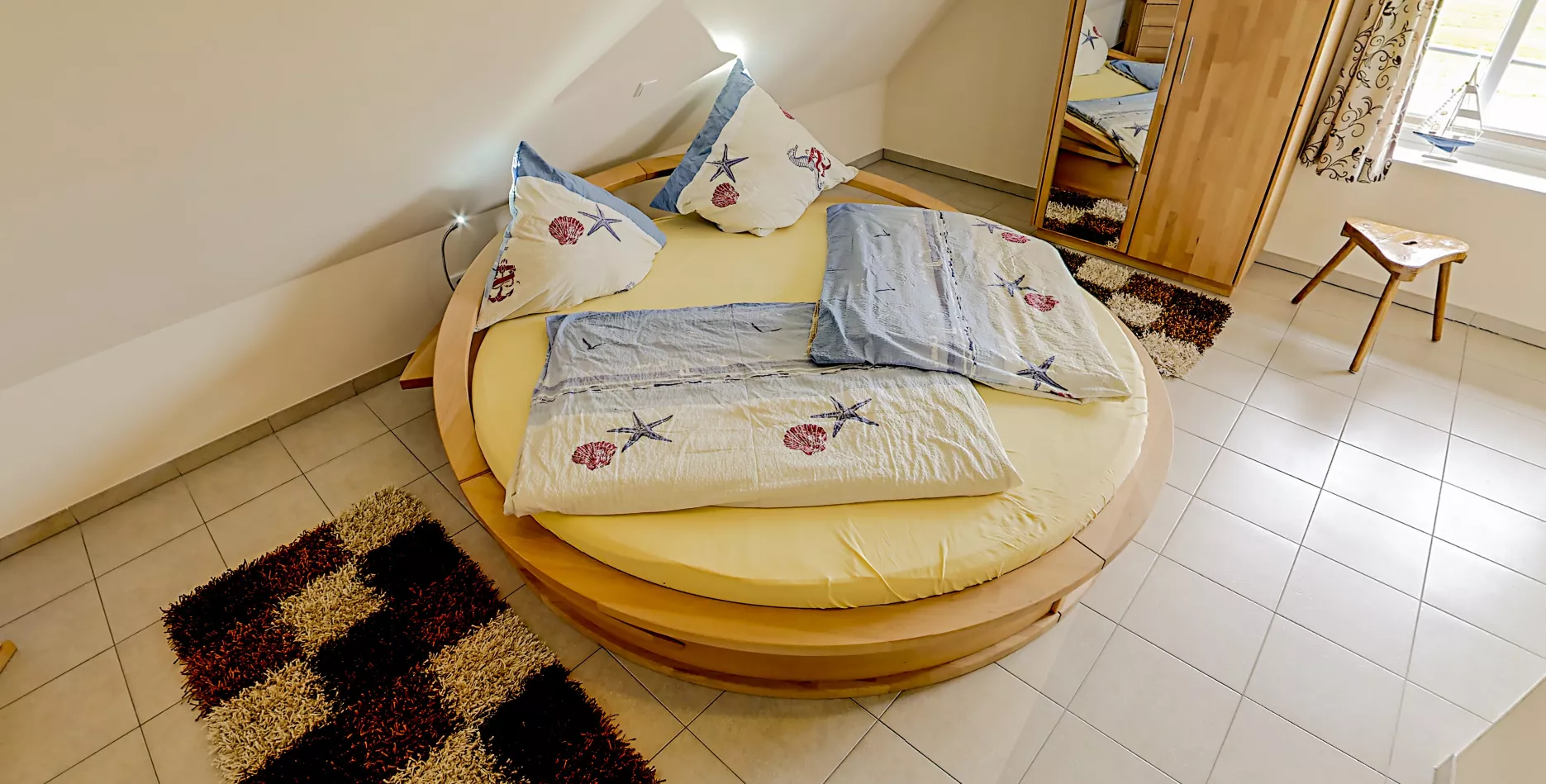 Schlafzimmer der Ferienwohnung Alte Kirche – Doppelbett mit Holzrahmen und Tageslicht