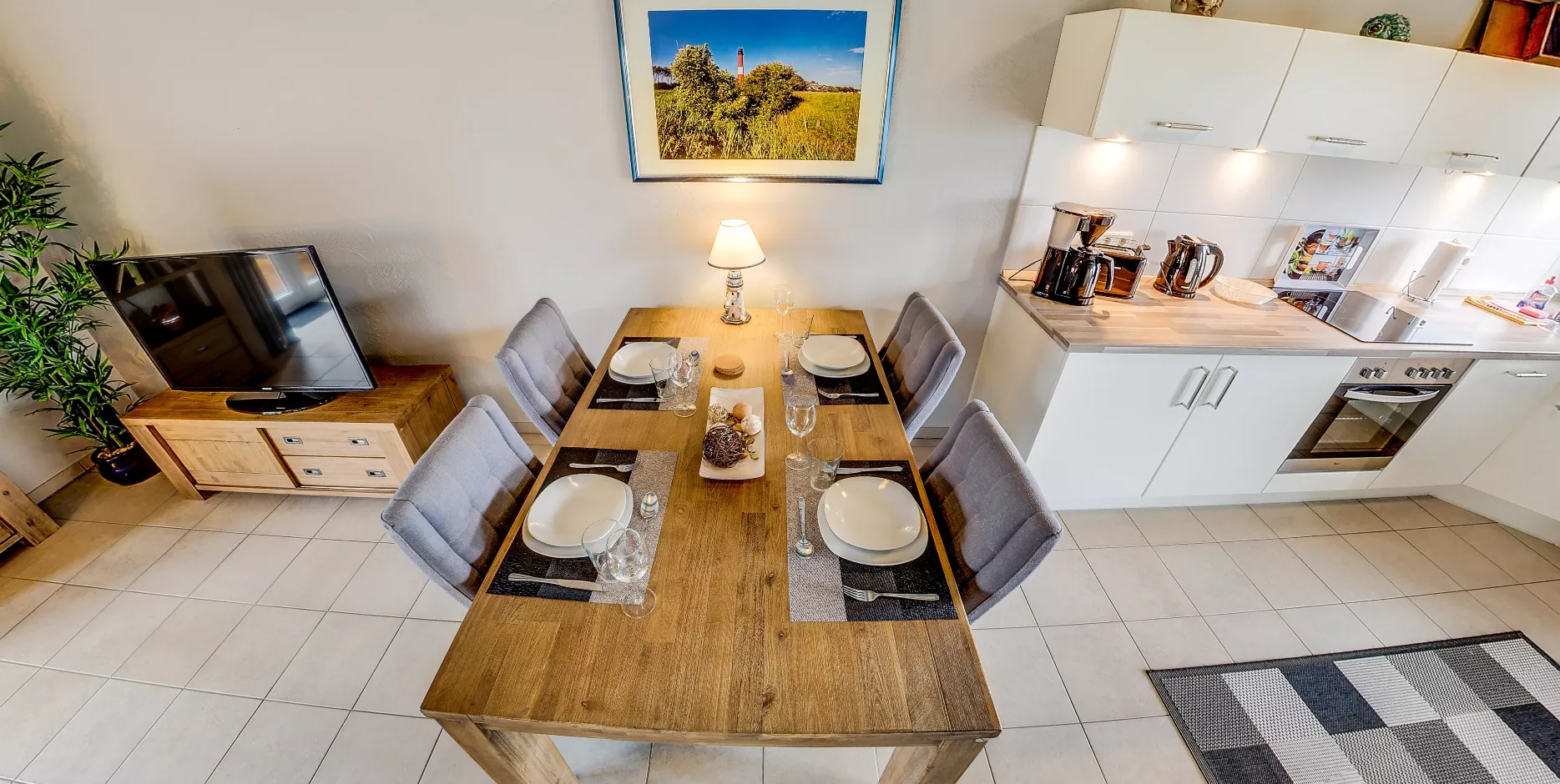 Essbereich Seegarden – gedeckter Tisch, Küche und TV-Ecke