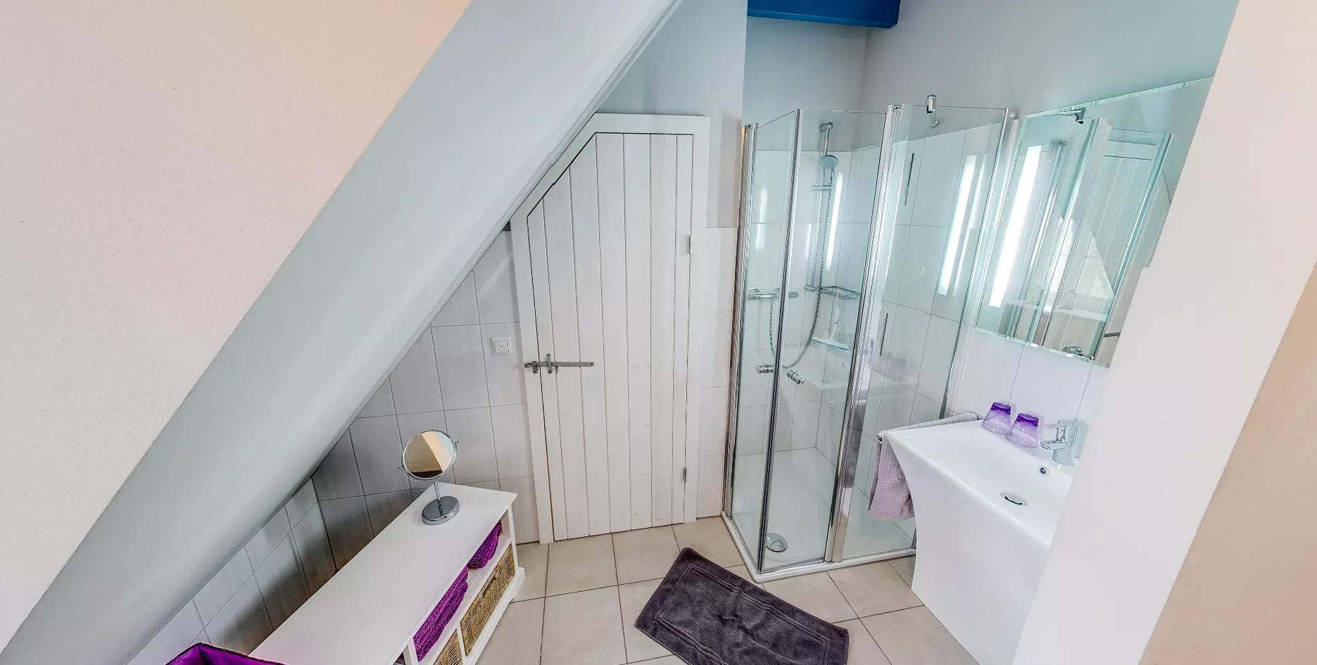 Badezimmer Seegarden – Dusche, violette Körbe und Spiegel mit Beleuchtung