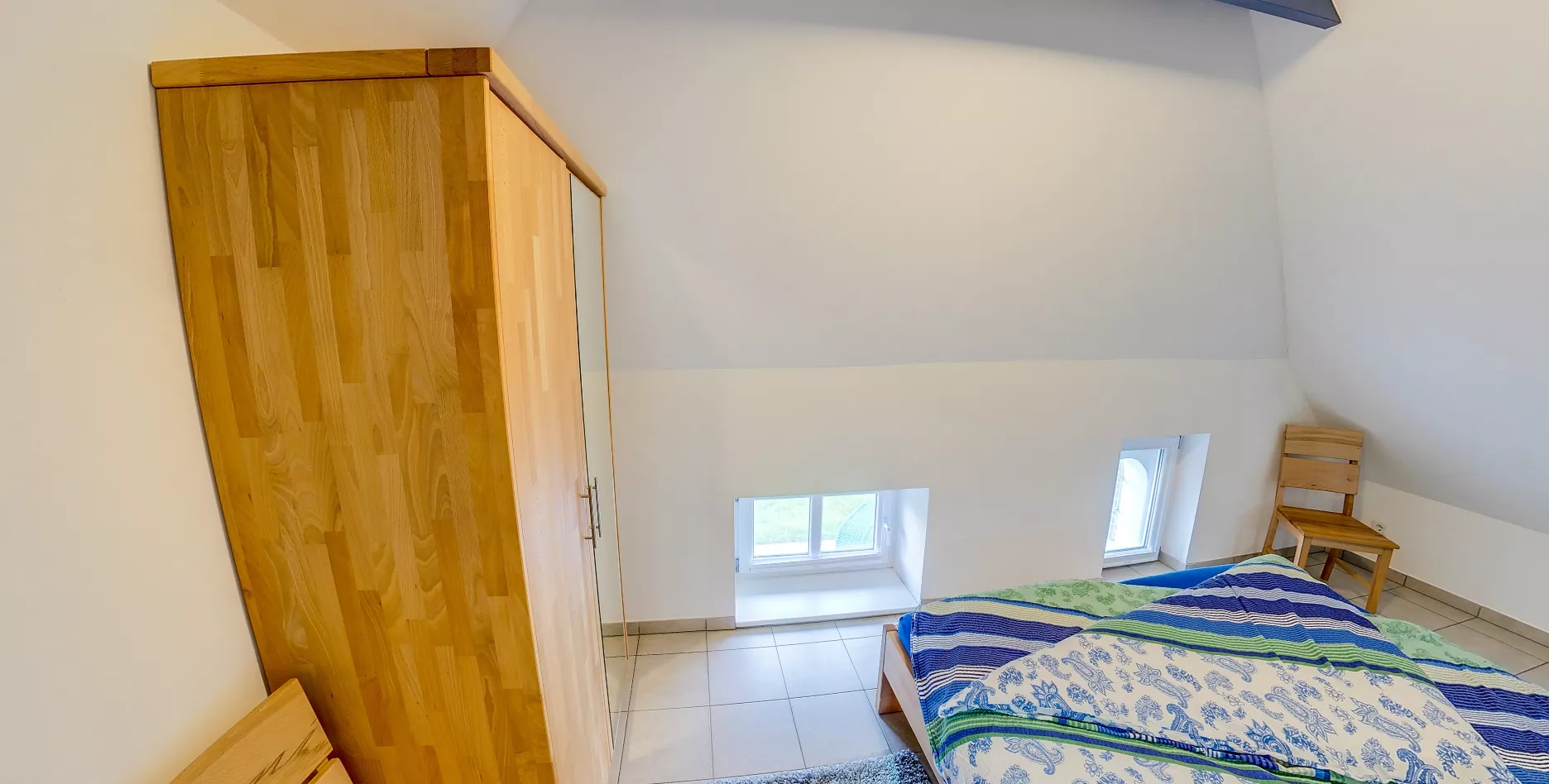 Schlafzimmer Vogelkoje – Doppelbett mit gemütlicher Bettwäsche unter Dachschräge