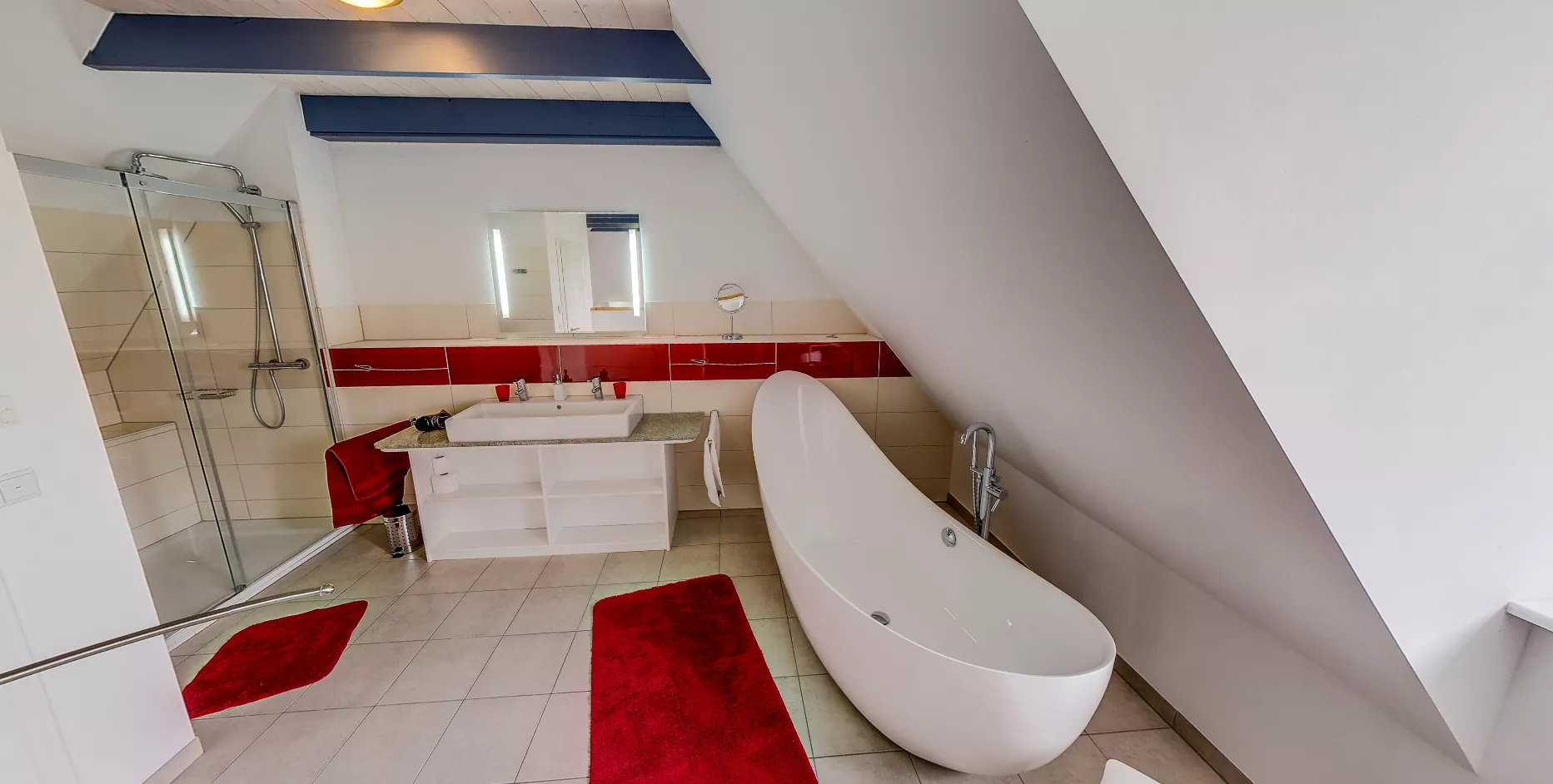 Badezimmer der Ferienwohnung Leuchtturm – freistehende Badewanne, Dusche und rote Fliesen