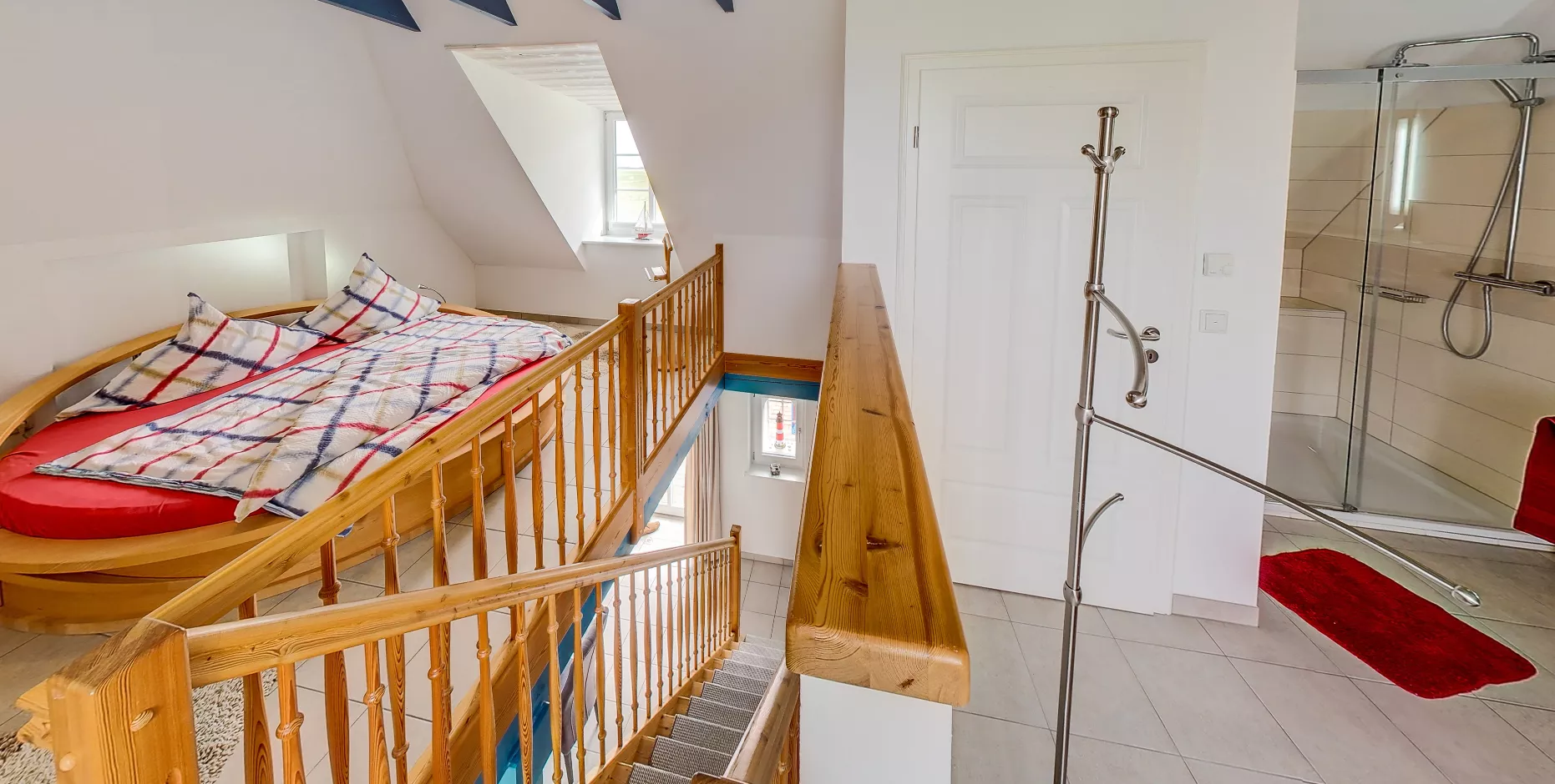 Rundbett mit angrenzender Dusche unter Dachschräge