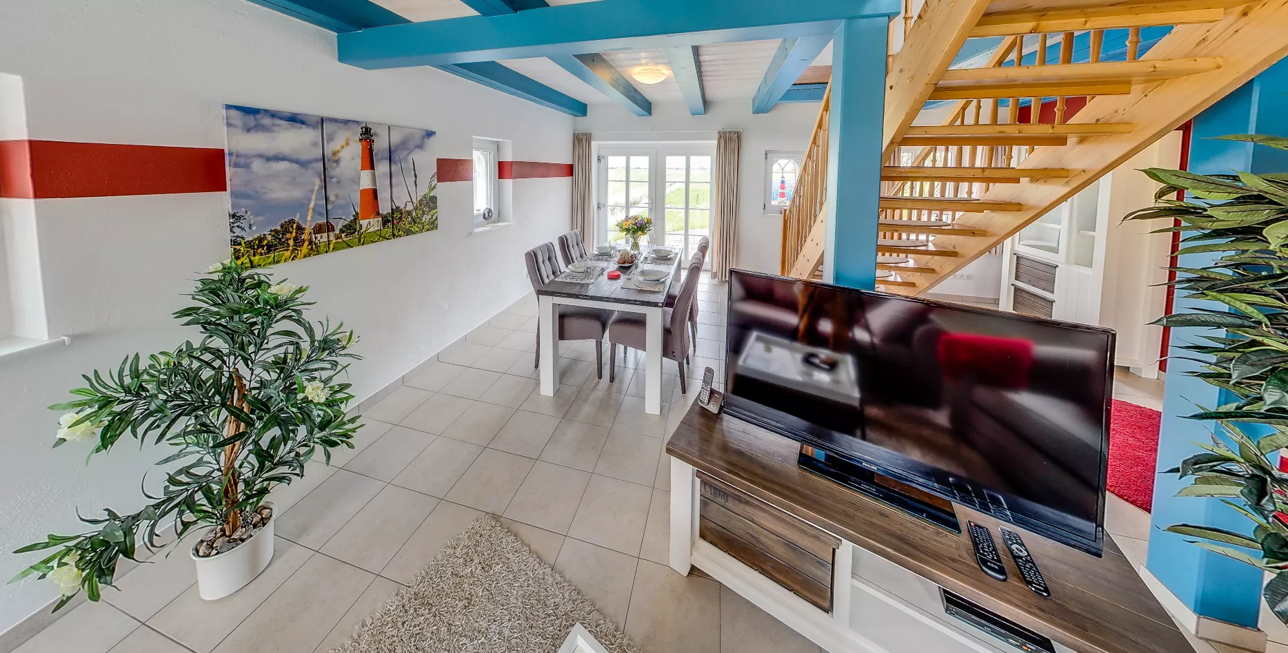 Essbereich Leuchtturm – gedeckter Tisch, Leuchtturmbild und Zugang zur Terrasse